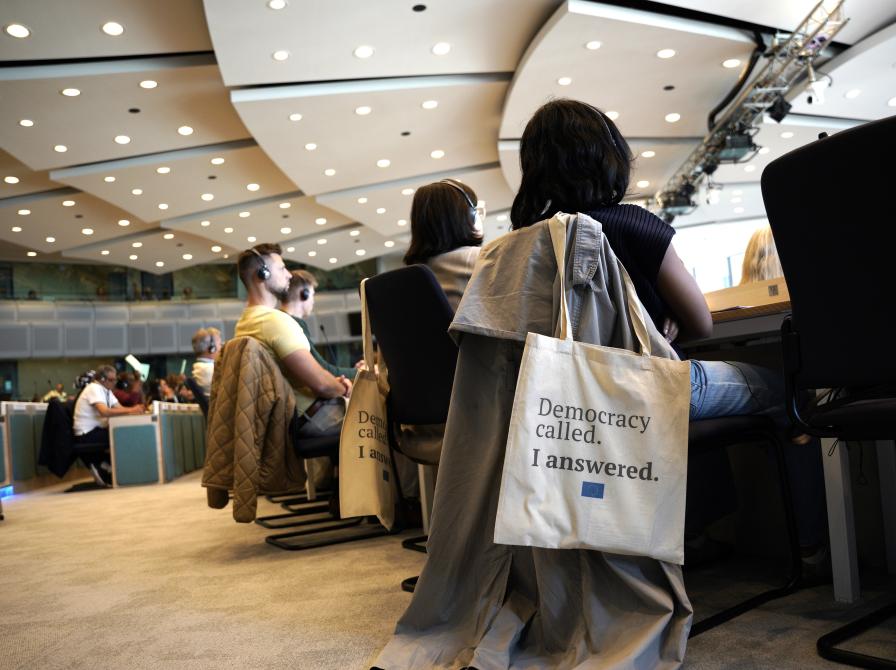 Personer i møderum og en mulepose med tekst på.